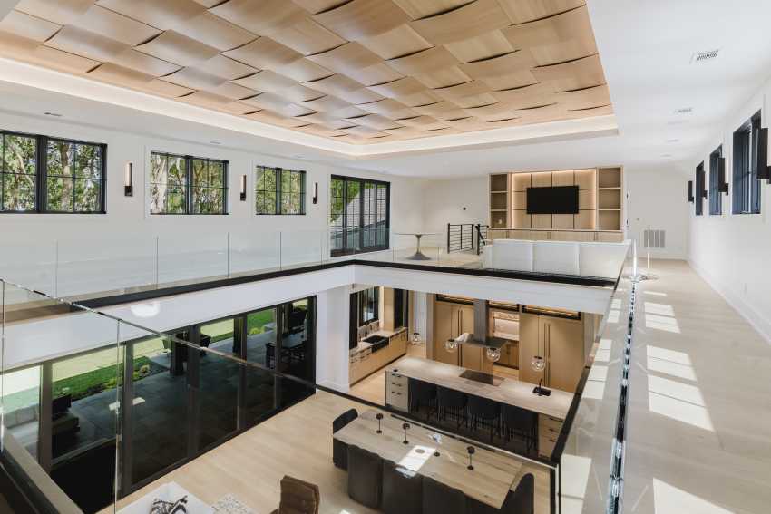 A photograph featuring the custom designed woven wood ceiling tiles installed above this gorgeous custom-built home's common room.
