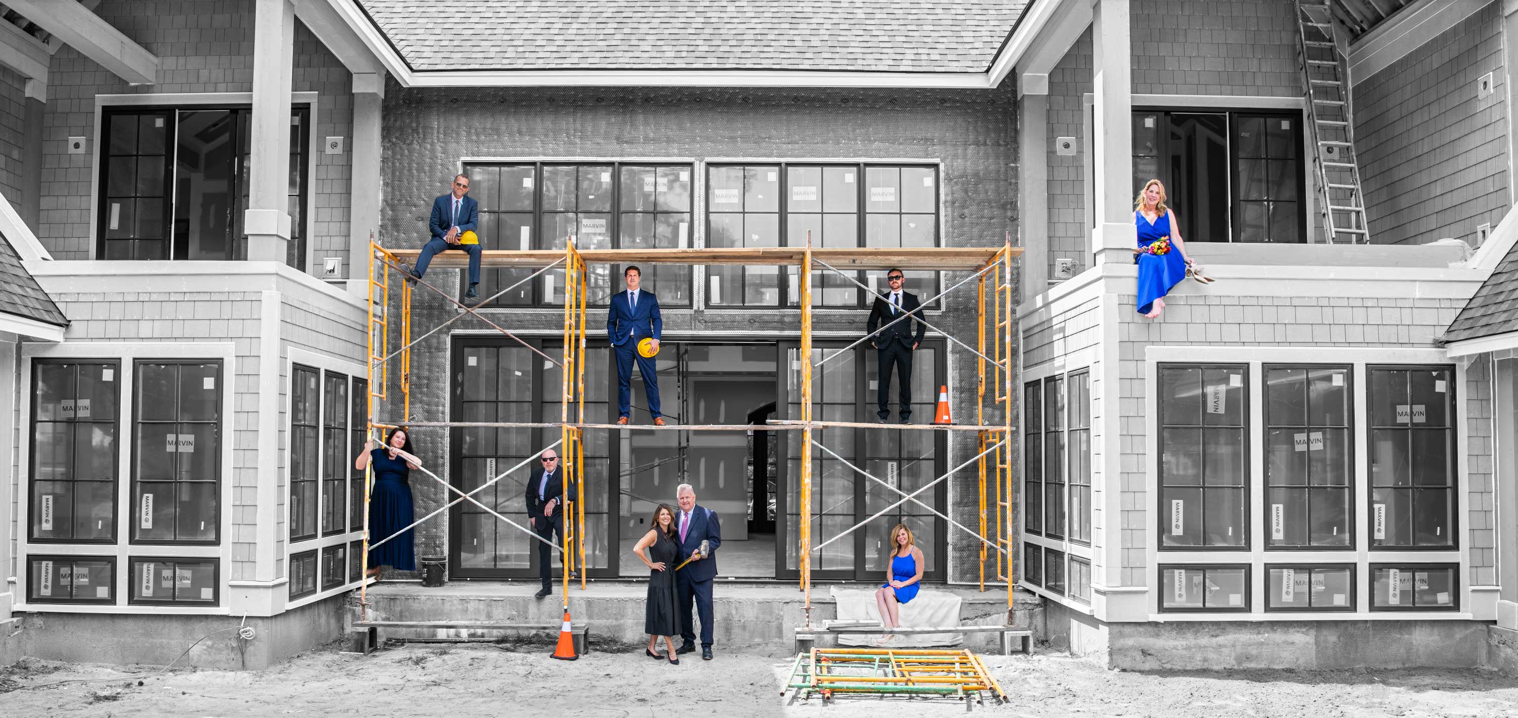A photograph showing the Southern Coastal Home Builders team arranged around the scaffolding of a home under construction.